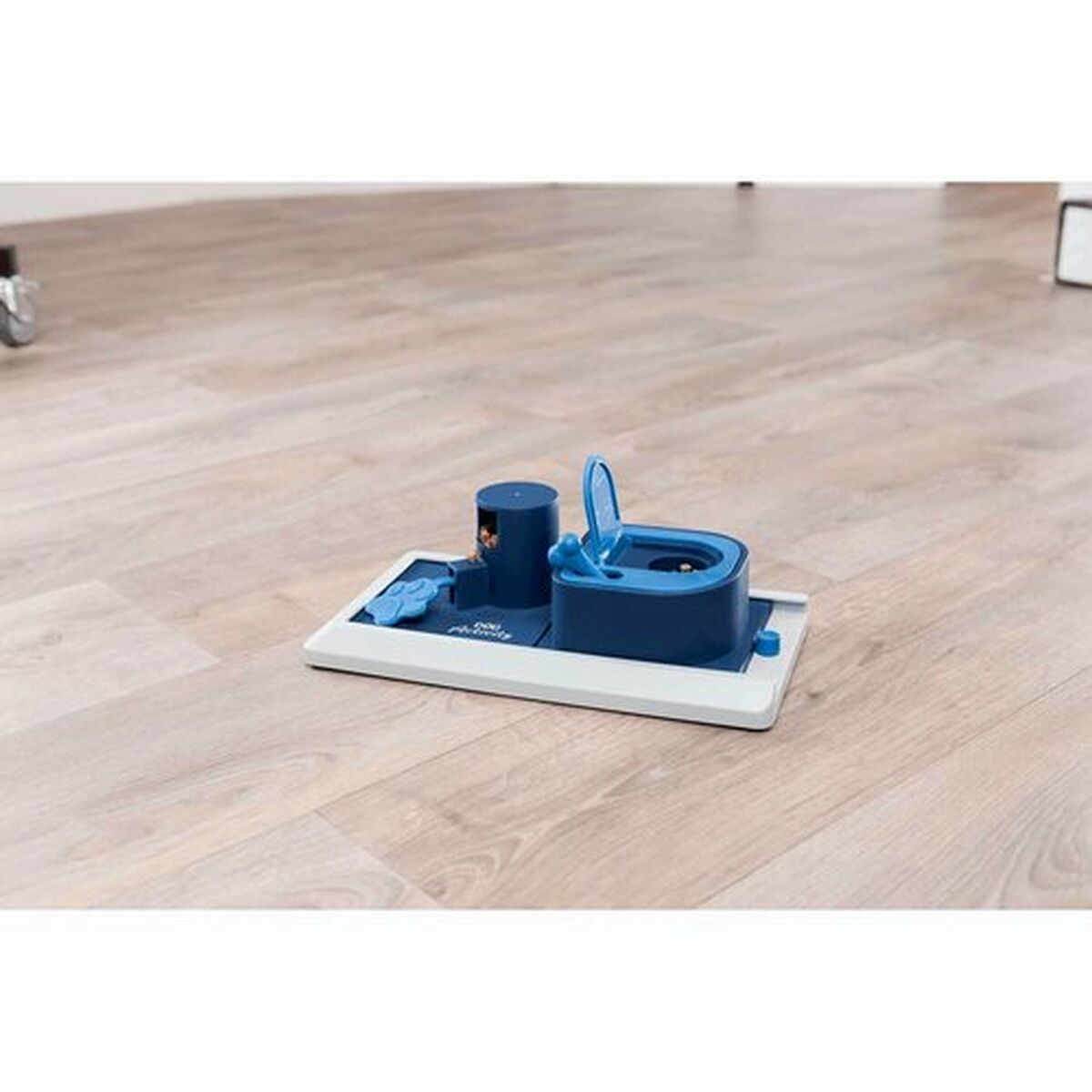 Juguete antideslizante para perros Trixie en color azul, diseñado para el entretenimiento canino, en un fondo de suelo laminado.