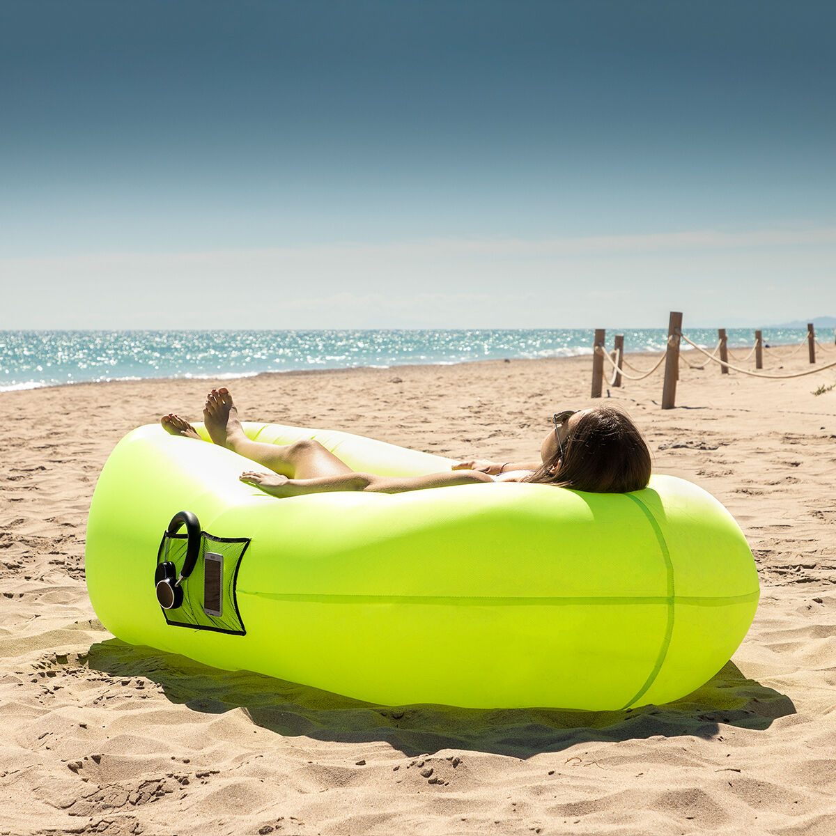 sofá hinchable InnovaGoods en la playa, ideal para relax y disfrutar del sol con comodidad.