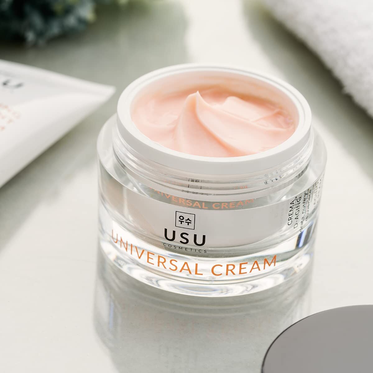 USU cosmetics universal facial cream in a clear jar with pink cream texture on top.
