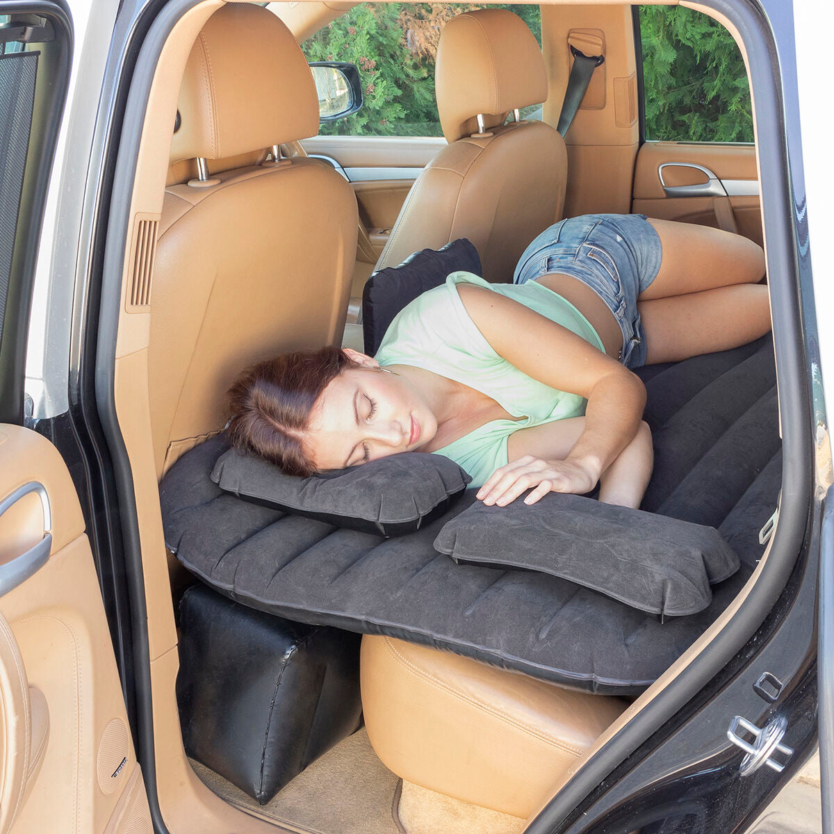 Mujer descansando sobre un colchón hinchable para coches Roleep InnovaGoods en el automóvil.